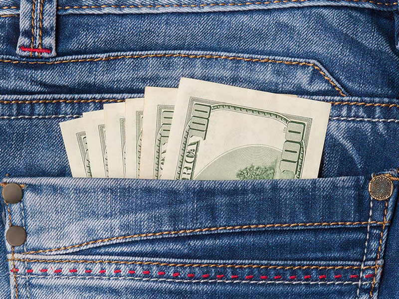 Stack of hundred-dollar bills tucked into the back pocket of blue jeans, symbolizing savings, promotions, or rebates.